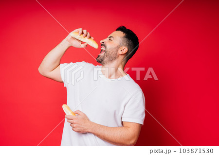 Man with freshly baked bread in the hands isolated on red background studio Man with freshly baked bread in the hands isolated on red background studio 103871530