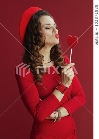 elegant woman in dress and beret on background sending kiss 103871988