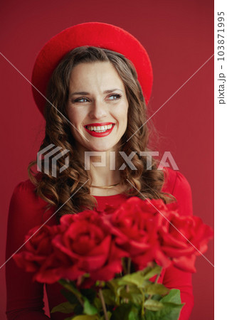 happy modern woman in red dress and beret on red background happy modern woman in red dress and beret on red background 103871995