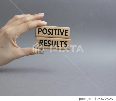 Positive results symbol. Concept words Positive results on wooden blocks. Beautiful grey background. Businessman hand. Business and Positive results concept. Copy space. 103872525