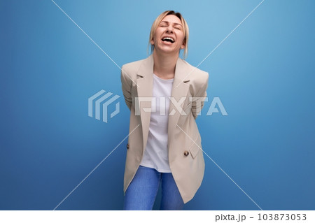 laughing blonde young business woman in jacket on studio background 103873053