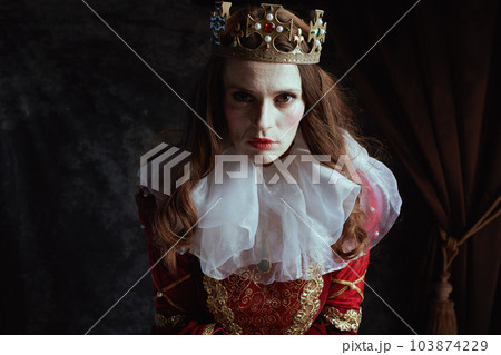 scary medieval queen in red dress with white collar and crown 103874229