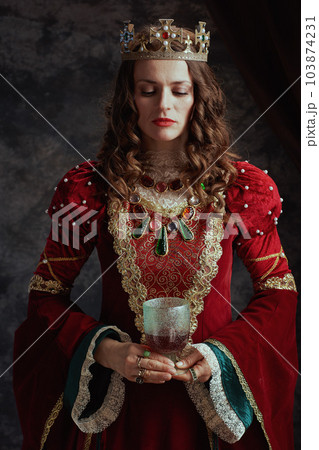medieval queen in red dress with goblet and crown 103874231