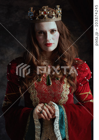 medieval queen in red dress with white makeup and crown 103874245