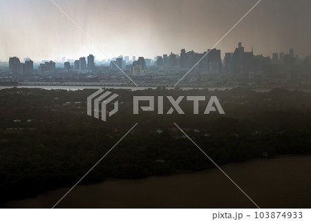 Misty Landscape of city skyscrapers covered before raining. Heavy dense smog fot during afternoon that Bangkok city cannot be seen clearly, Aerial top view of city on a foggy day. 103874933