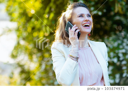 happy stylish woman in city talking on smartphone happy stylish woman in city talking on smartphone 103874971