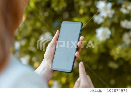 Elegant female in dress and jacket in city using smartphone app Elegant female in dress and jacket in city using smartphone app 103874972