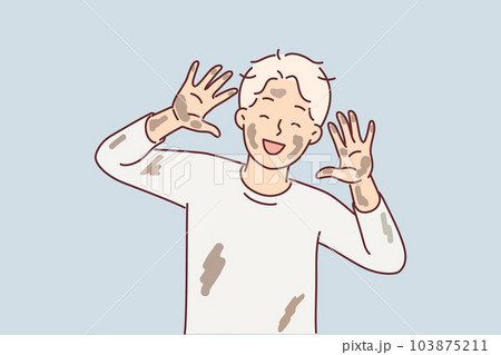 Cheerful dirty boy pre-adolescent age laughs and shows palms and face stained with clay from puddle 103875211