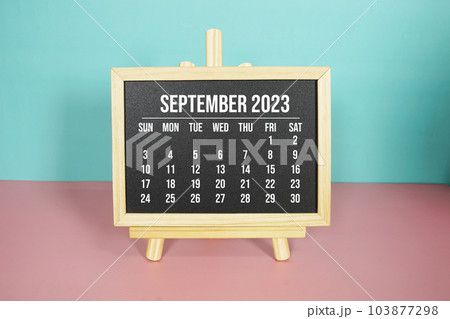 September 2023 monthly calendar on easel stand on pink and blue background 103877298