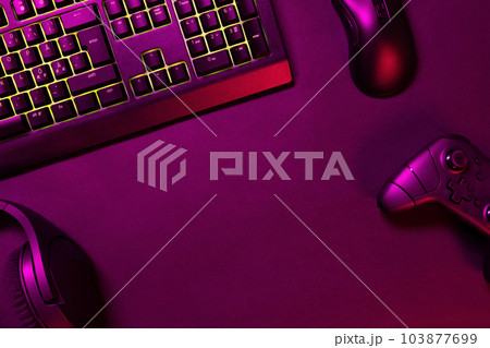 Green lit keyboard with gaming gadgets Green lit keyboard with gaming gadgets 103877699