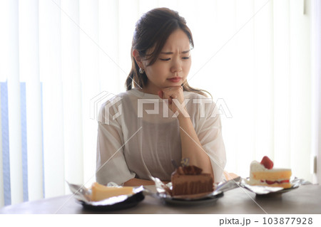 どのケーキを食べるか悩む女性 どのケーキを食べるか悩む女性 103877928