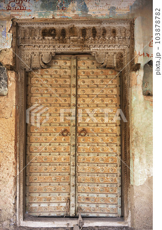 Decorative wooden door of an old building near fort, located in Bissau, Shekhawati, Rajasthan, India Decorative wooden door of an old building near fort, located in Bissau, Shekhawati, Rajasthan, India 103878782