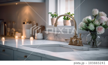 Fragment of a classic kitchen with a window. Marble countertop with built-in sink, tall old-fashioned faucet, kitchen utensils, green plants in pots, flowers in a glass vase. Fragment of a classic kitchen with a window. Marble countertop with built-in sink, tall old-fashioned faucet, kitchen utensils, green plants in pots, flowers in a glass vase. 103883241