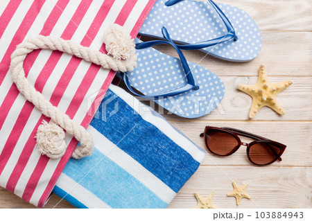 beach accessories flat lay top view on colored background Summer travel concept. Bag with starfish and sea shell. Top view 103884943