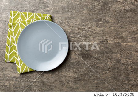Top view on colored background empty round gray plate on tablecloth for food. Empty dish on napkin with space for your design 103885009