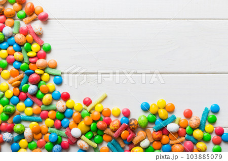 Mixed collection of colorful candy, on colored background. Flat lay, top view. frame of colorful chocolate coated candy 103885079