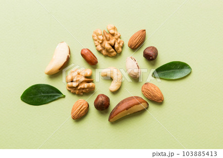 Composition of nuts , flat lay - mix hazelnuts, cashews, almonds on table background. healthy eating concepts and food background Composition of nuts , flat lay - mix hazelnuts, cashews, almonds on table background. healthy eating concepts and food background 103885413
