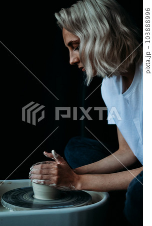 ceramist works behind a potter's wheel ceramist works behind a potter's wheel 103888996