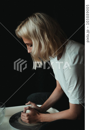 ceramist works behind a potter's wheel  103889005