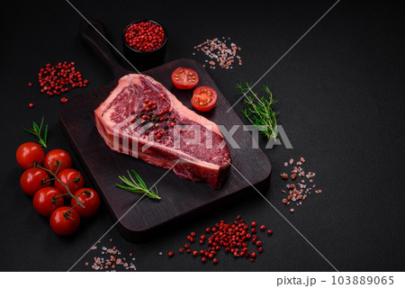 Fresh juicy raw new york beef steak with salt, spices and herbs Fresh juicy raw new york beef steak with salt, spices and herbs 103889065
