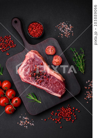 Fresh juicy raw new york beef steak with salt, spices and herbs 103889066