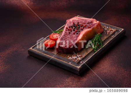 Fresh juicy raw new york beef steak with salt, spices and herbs Fresh juicy raw new york beef steak with salt, spices and herbs 103889098