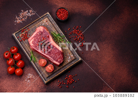 Fresh juicy raw new york beef steak with salt, spices and herbs Fresh juicy raw new york beef steak with salt, spices and herbs 103889102