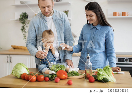 Young family cooking natural balanced food together indoors 103889812