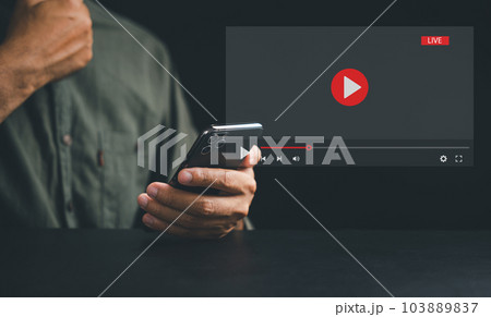Experience the power of a smartphone for live streaming, with a man engrossed in video content on the screen. Discover the seamless integration of technology and media in today's connected lifestyle. 103889837
