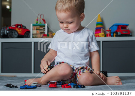 Toddler boy plays in playroom with educational toys... Toddler boy plays in playroom with educational toys... 103891137