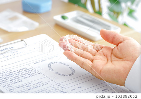 歯科医療で使用するマウスピースの説明をする歯科医 歯科医療で使用するマウスピースの説明をする歯科医 103892052