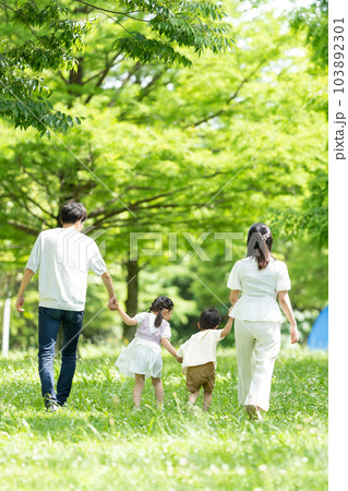 手をつないで歩く家族 103892301