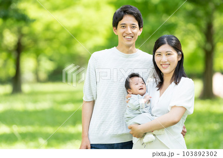 赤ちゃんを抱っこする若い夫婦 赤ちゃんを抱っこする若い夫婦 103892302