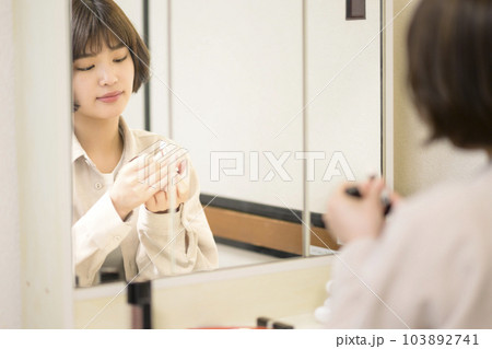 メイクをする女性の鏡越しのポートレート 103892741