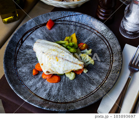 Baked dorado fish fillet with broccoli, carrot and pepper 103893697