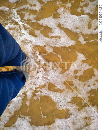 Person standing in the sea wave 103896489