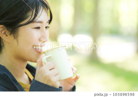 自然の中でコーヒーを飲む女性 103896598