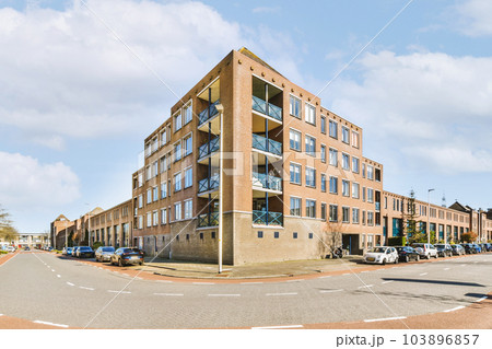 a street corner with cars parked on the side and an apartment building in the back ground to the other buildings a street corner with cars parked on the side and an apartment building in the back ground to the other buildings 103896857