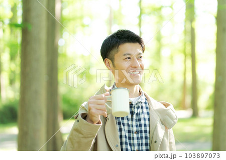 森の中でコーヒーを飲む男性の写真 103897073