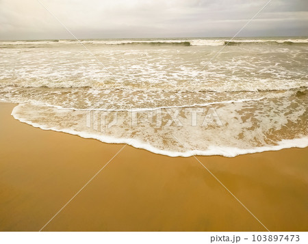 Sea beach in with white foam wave 103897473