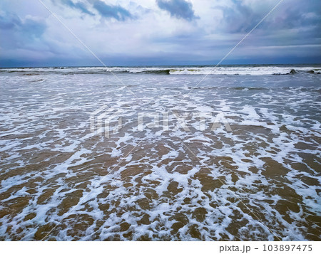 Clouds over beautiful waves on the beach Clouds over beautiful waves on the beach 103897475
