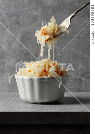 Bowl of sauerkraut with a carrot. 103898281