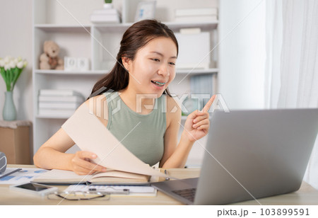 Asian student chatting or exchanging knowledge through laptop video call, Education through wireless education system, Conversations with teachers and classmates, Online learning, Study at home. Asian student chatting or exchanging knowledge through laptop video call, Education through wireless education system, Conversations with teachers and classmates, Online learning, Study at home. 103899591