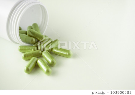 Herbal medicine capsules with bottle on white background 103900383