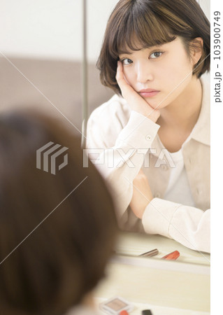 メイクをする女性の鏡越しのポートレート 103900749