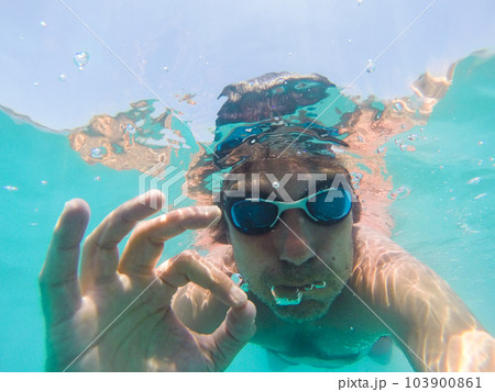 Underwater view of a man swimming in the sea Underwater view of a man swimming in the sea 103900861