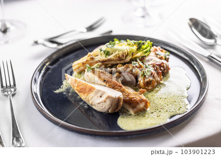 Chicken breasts with green salad and cheese sauce on a dark plate 103901223