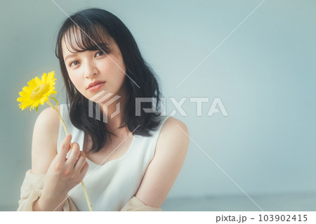 ひまわりの花を持つ若い女性 ひまわりの花を持つ若い女性 103902415
