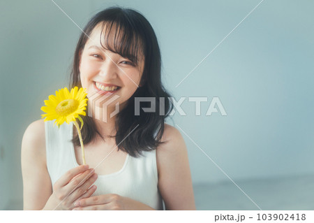 ひまわりの花を持つ若い女性 ひまわりの花を持つ若い女性 103902418