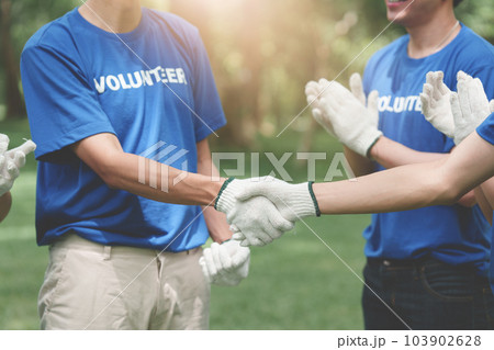 Young Asian Volunteers handshake and working together at park area. Ecology, Charitable organization concept Young Asian Volunteers handshake and working together at park area. Ecology, Charitable organization concept 103902628